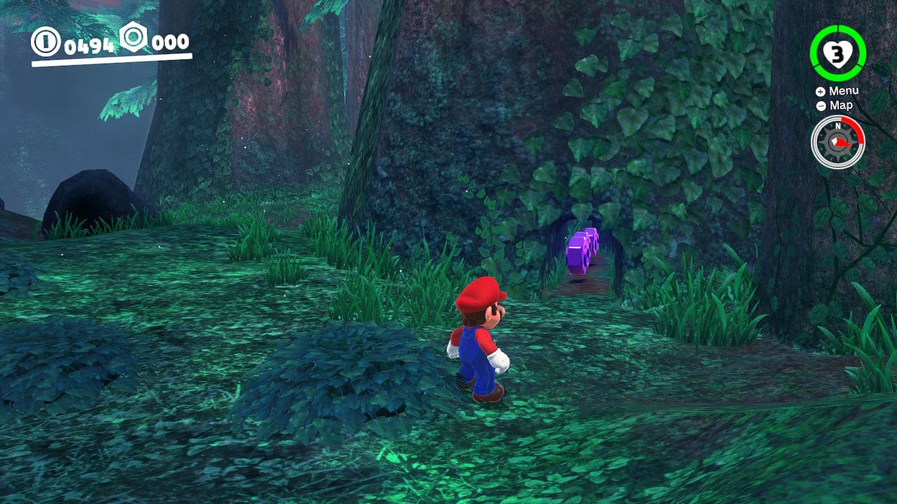 Mario standing next to a tree with purple coins under it in the Wooded Kingdom in Super Mario Odyssey.