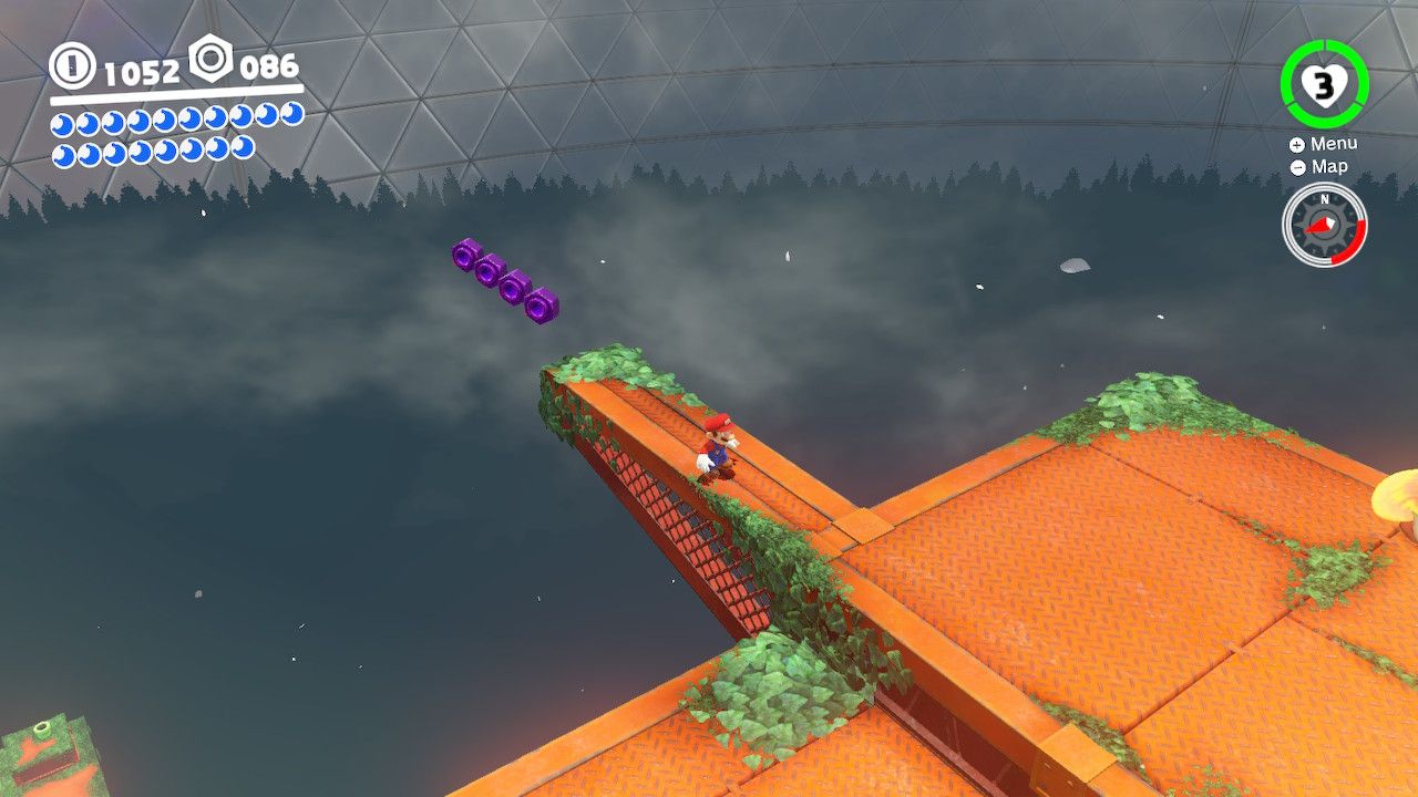 Mario at the top of the Wooded Kingdom with purple coins nearby in Super Mario Odyssey.