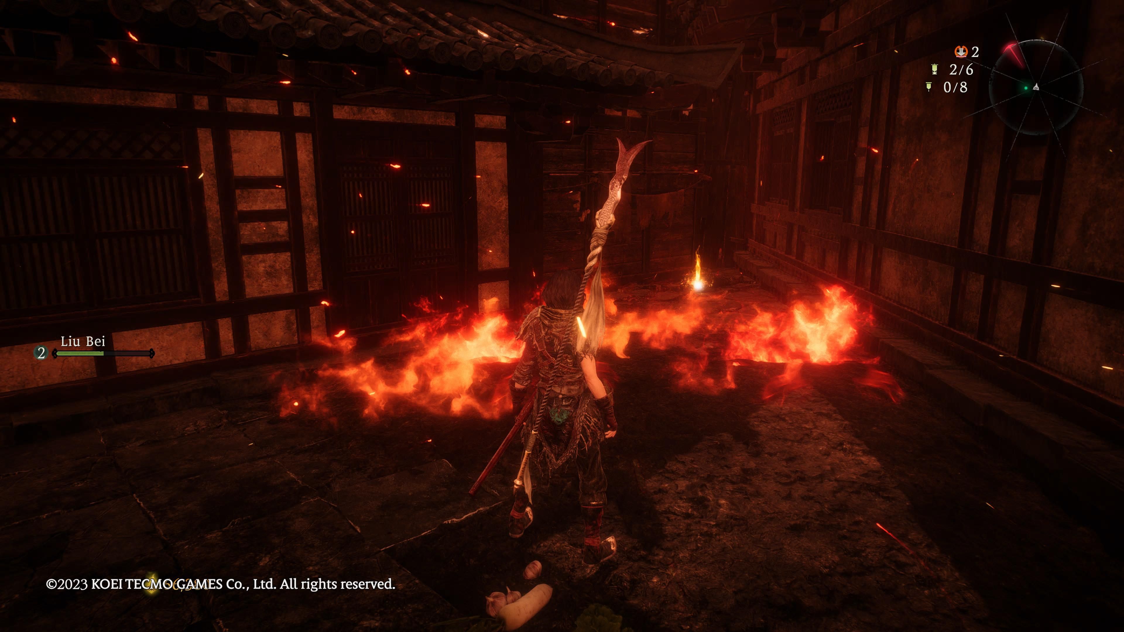 Wo Long: Fallen Dynasty - we look over at an item behind a patch of fire in the town