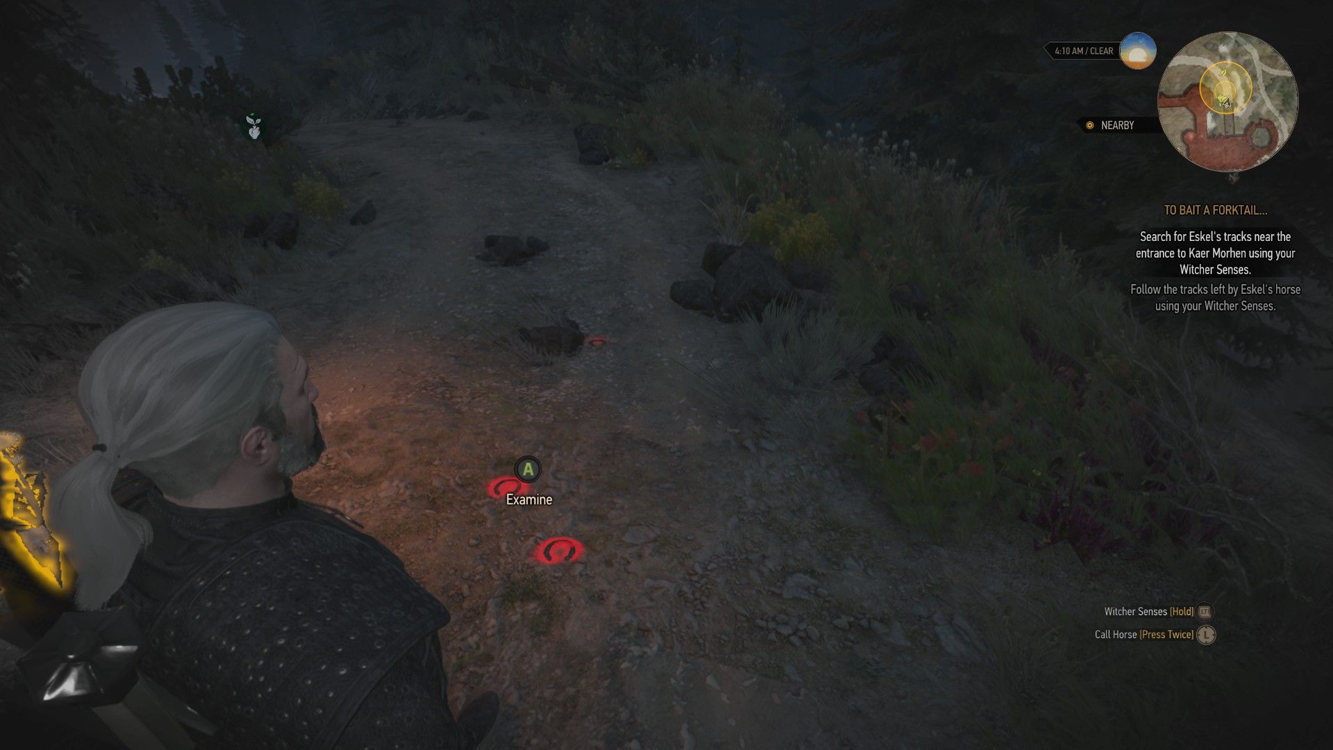 A screenshot of Geralt looking at a set of hoofprints in the ground near Kaer Morhen.