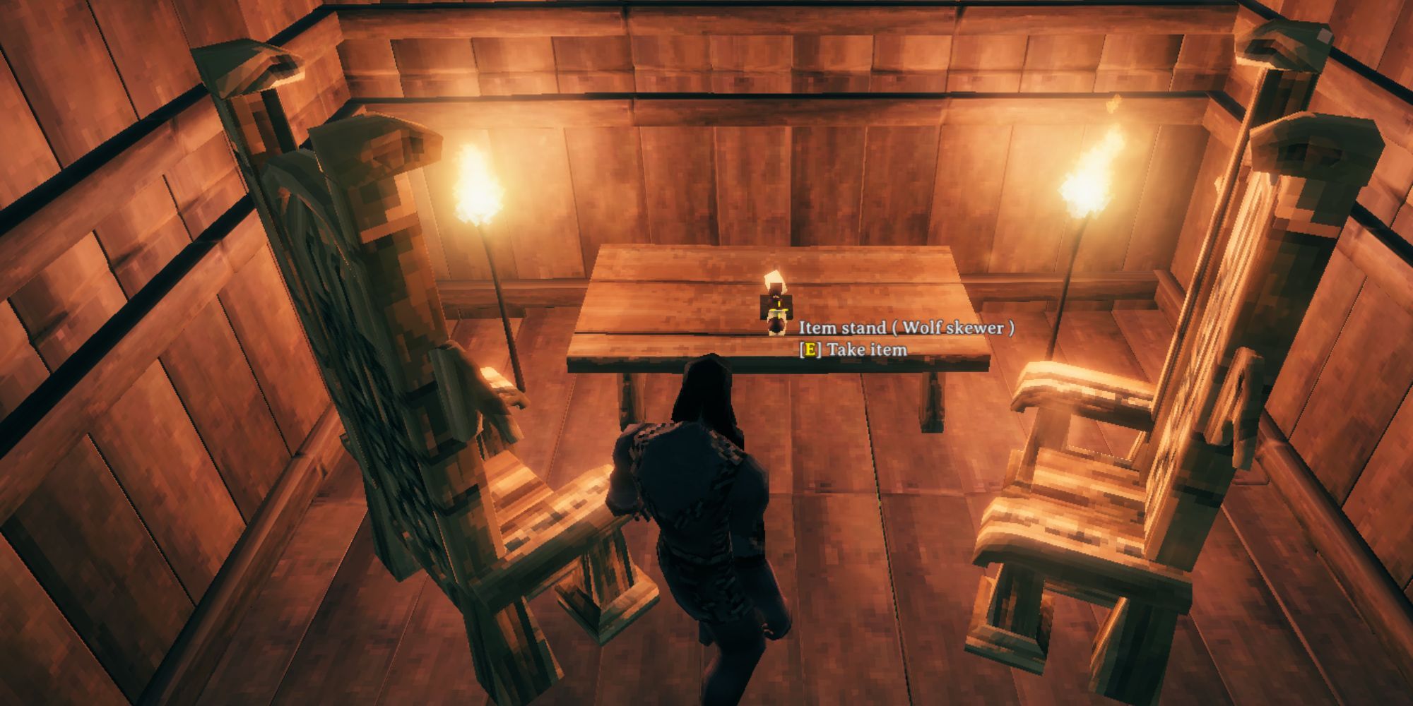 Valheim character in a Viking house in front of a Wolf Skewer