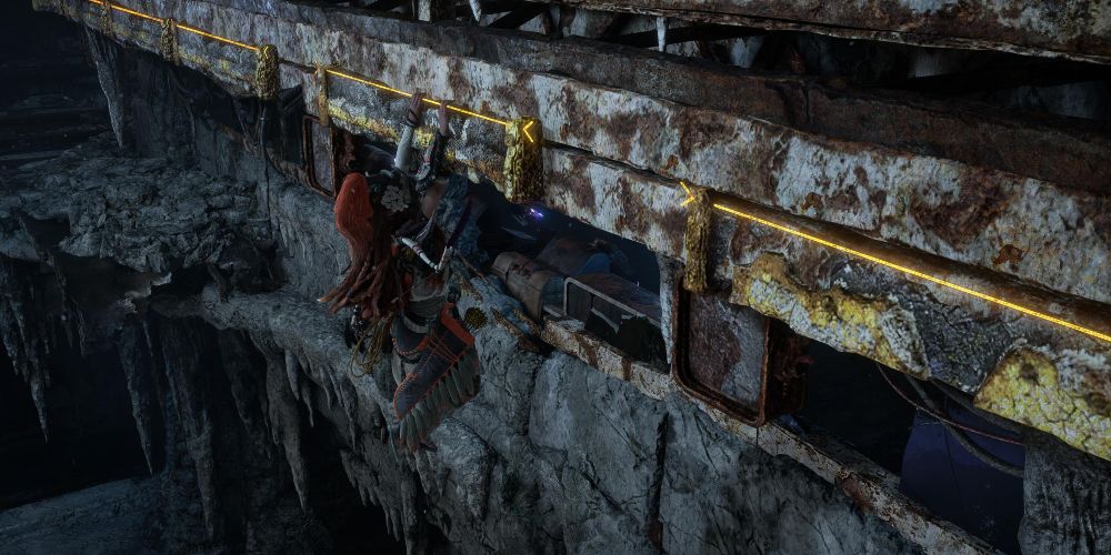 Aloy climbs across ruined ledges in Murmuring Hollow in Horizon Forbidden West Burning Shores