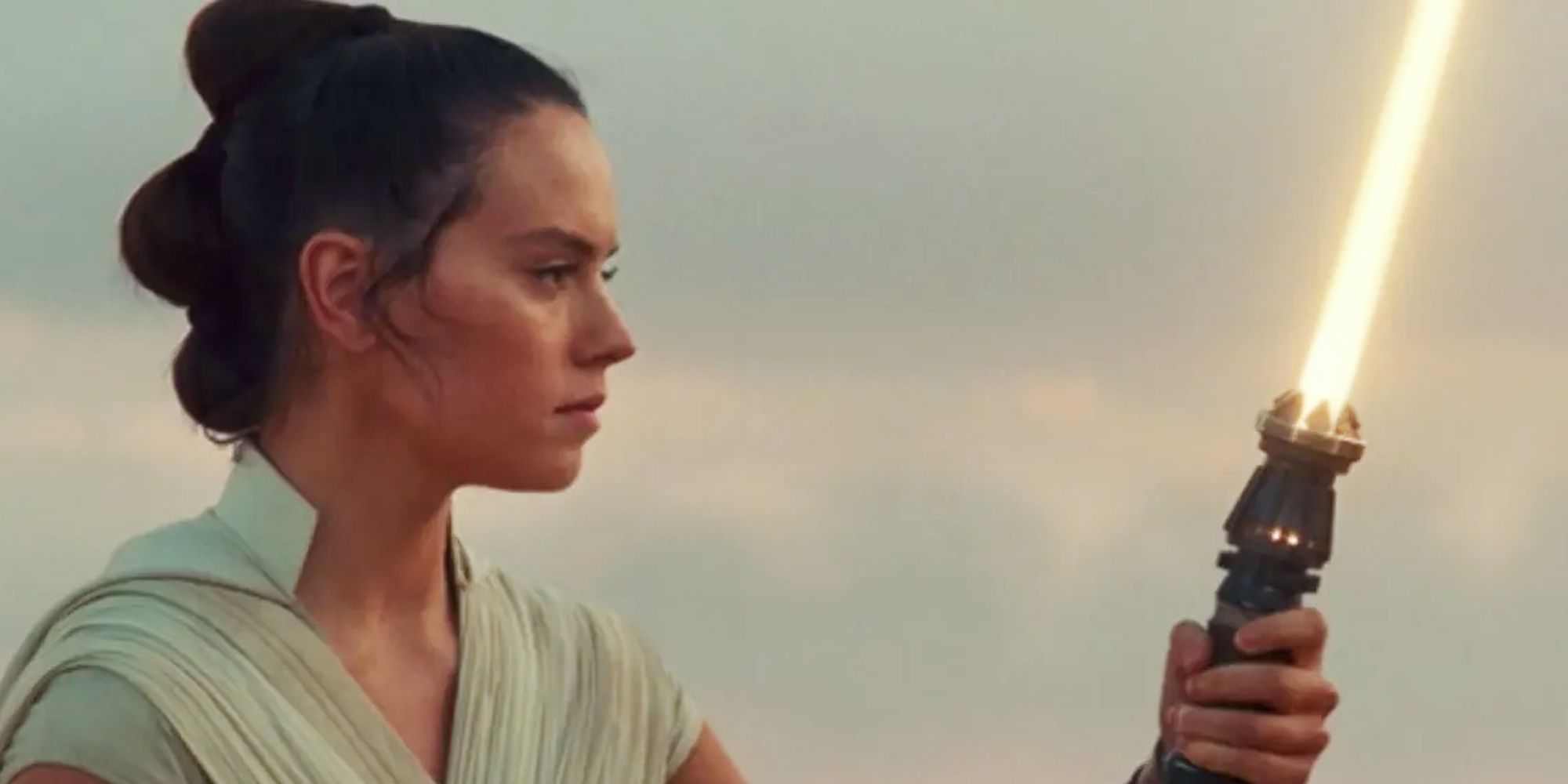 Rey holding gold lightsaber