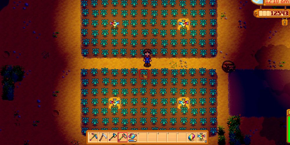 Stardew Valley Farmer standing in fields with prismatic sprinklers, more prismatic tools on the inventory bar