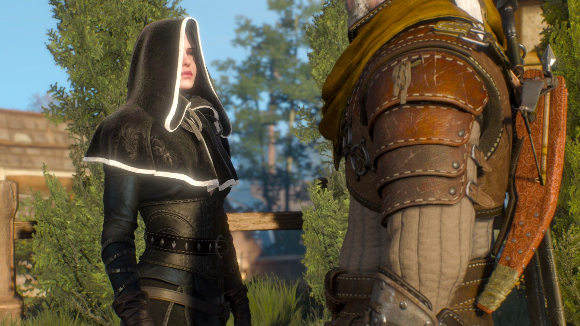 Geralt and Yennefer stand in broad daylight as they speak in Oxenfurt, with the former in his armor and the latter in a cloak.
