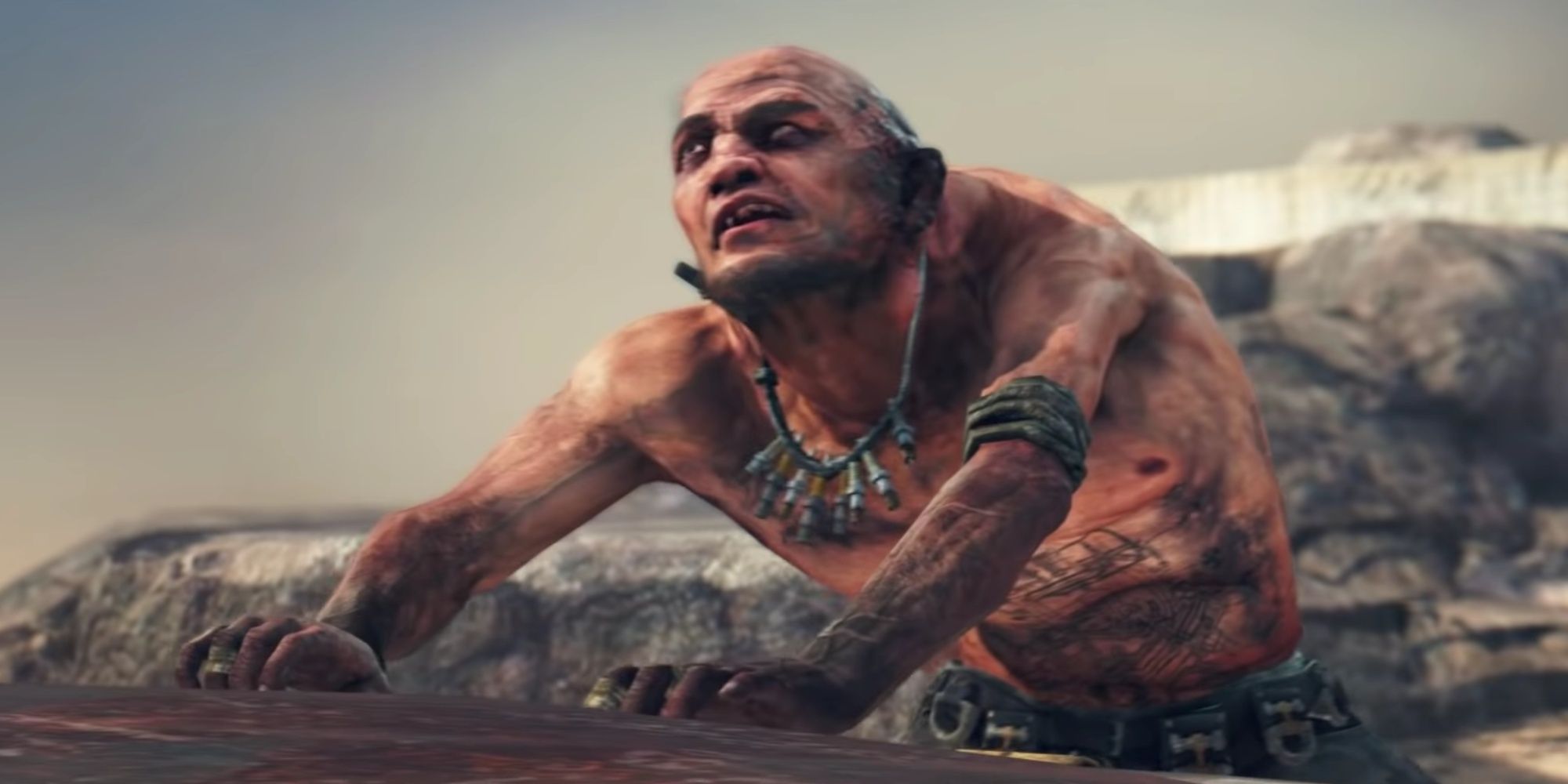 Chumbucket looking up to somebody standing on a tower, placing his dirty hands on the Magnum Opus vehicle, in Mad Max.