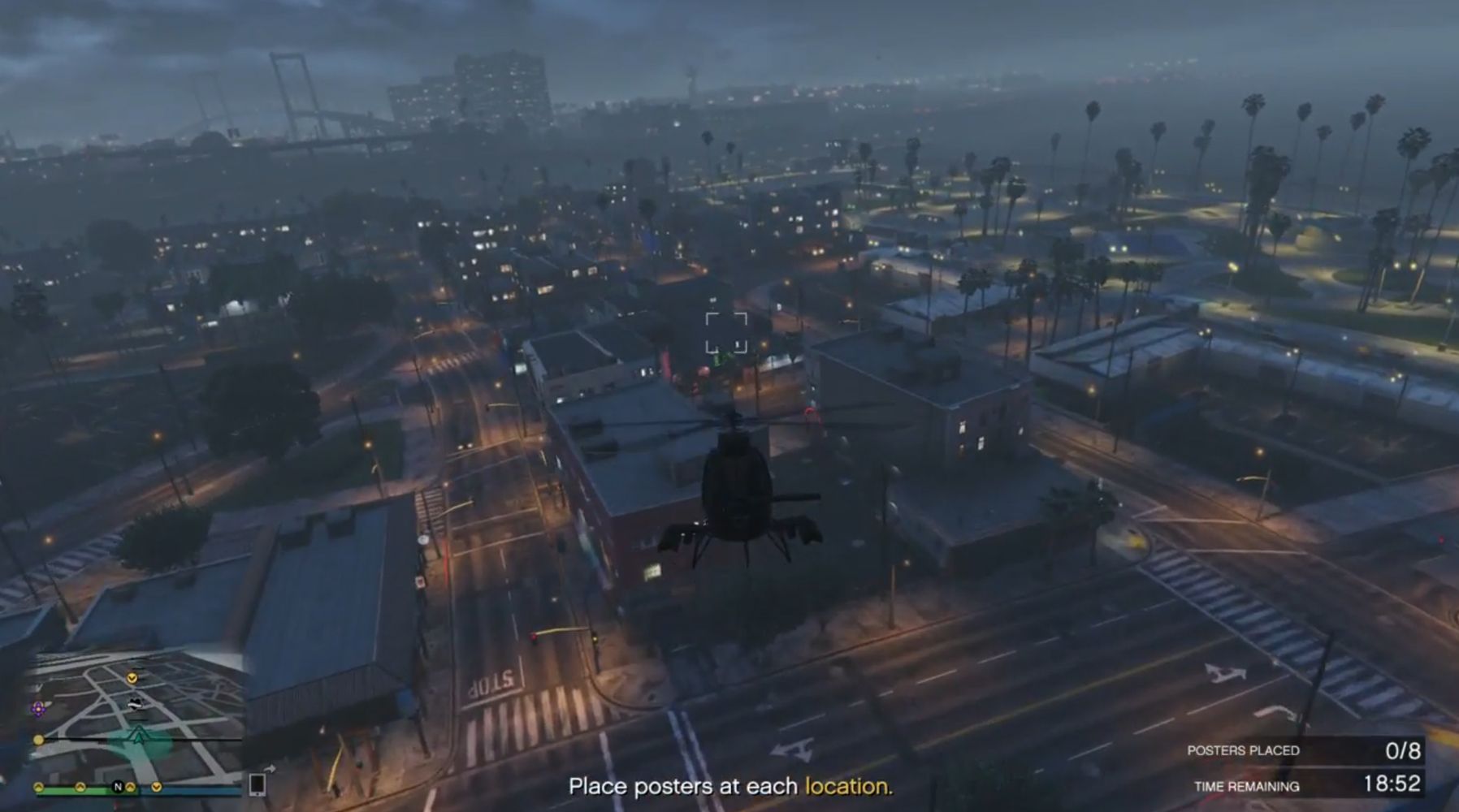 Image depicts a player in Grand Theft Auto Online flying a helicopter over Los Santos. The text at the bottom of the screen reads 'Place Posters at each location'.