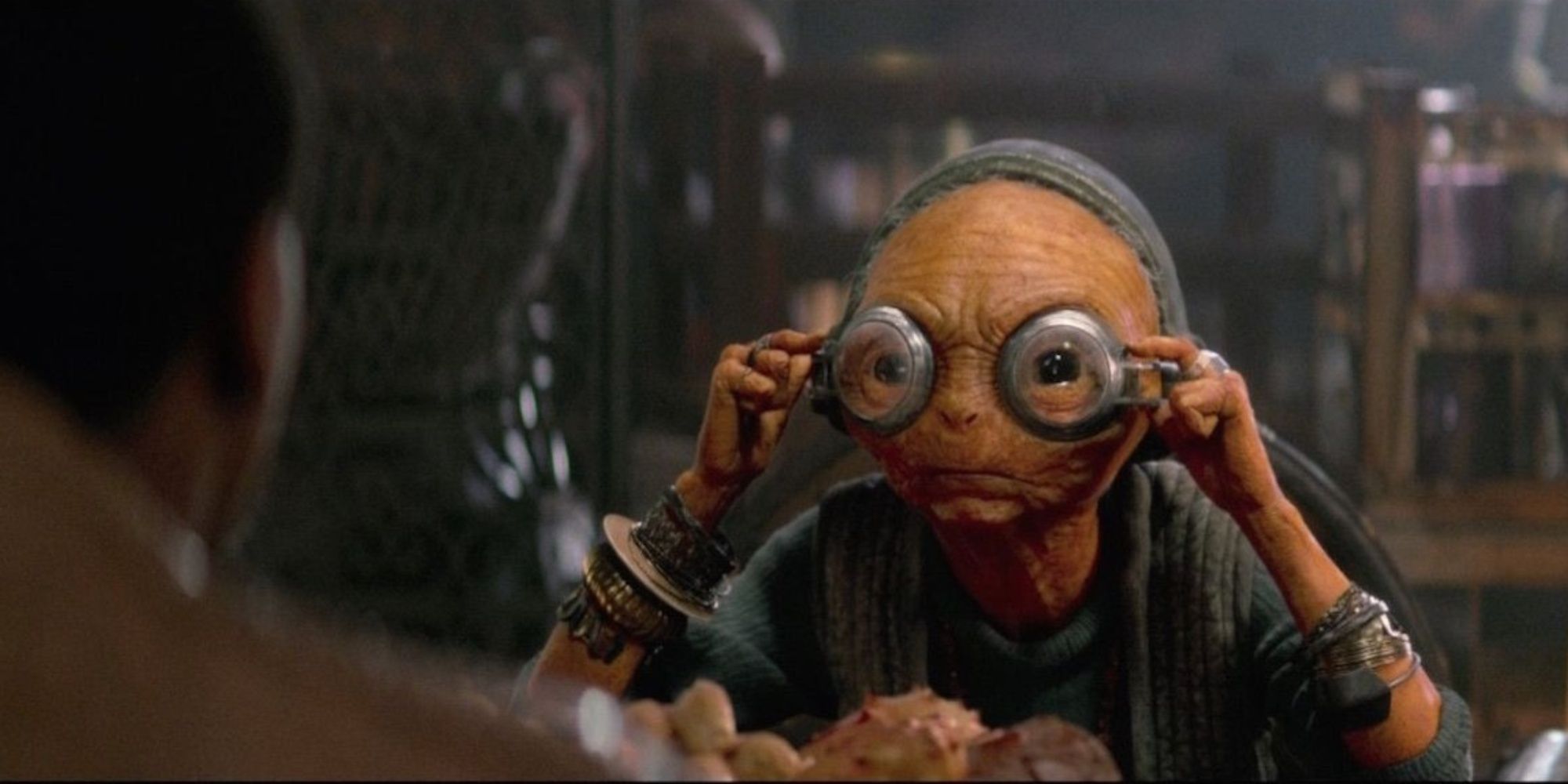 Maz adjusting her goggles as she takes a look at Finn sitting across from her in The Force Awakens.