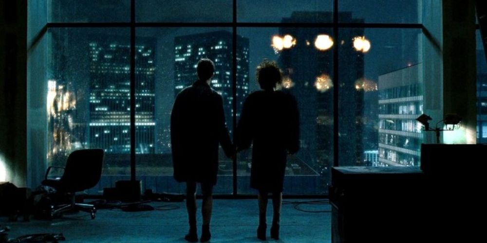 the Narrator (Edward Norton) and Maria (Helena Bonham Carter) hold hands as they watch buildings explode in the final scene of Fight Club (1999)