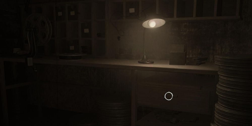 a wooden workbench lit by a single lamp in layers of fear 2023