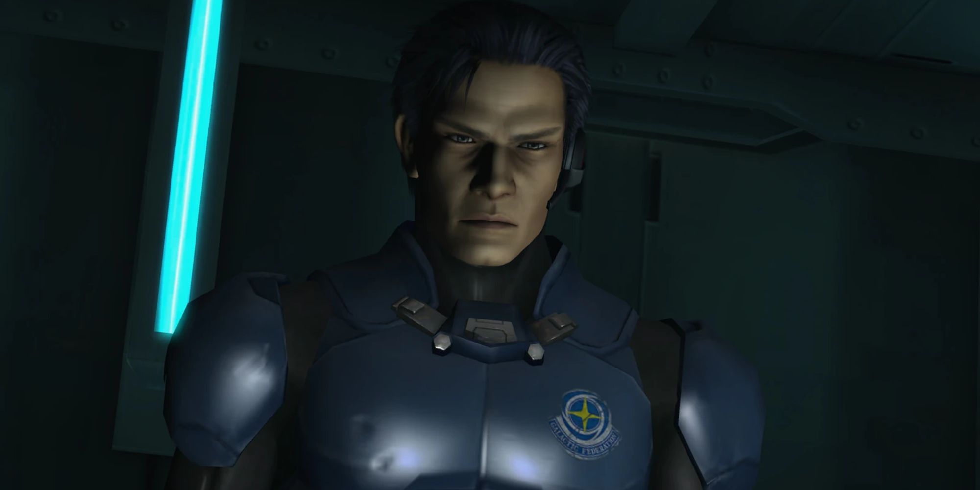 Adam Malkovich stands in a dark room with an earpiece