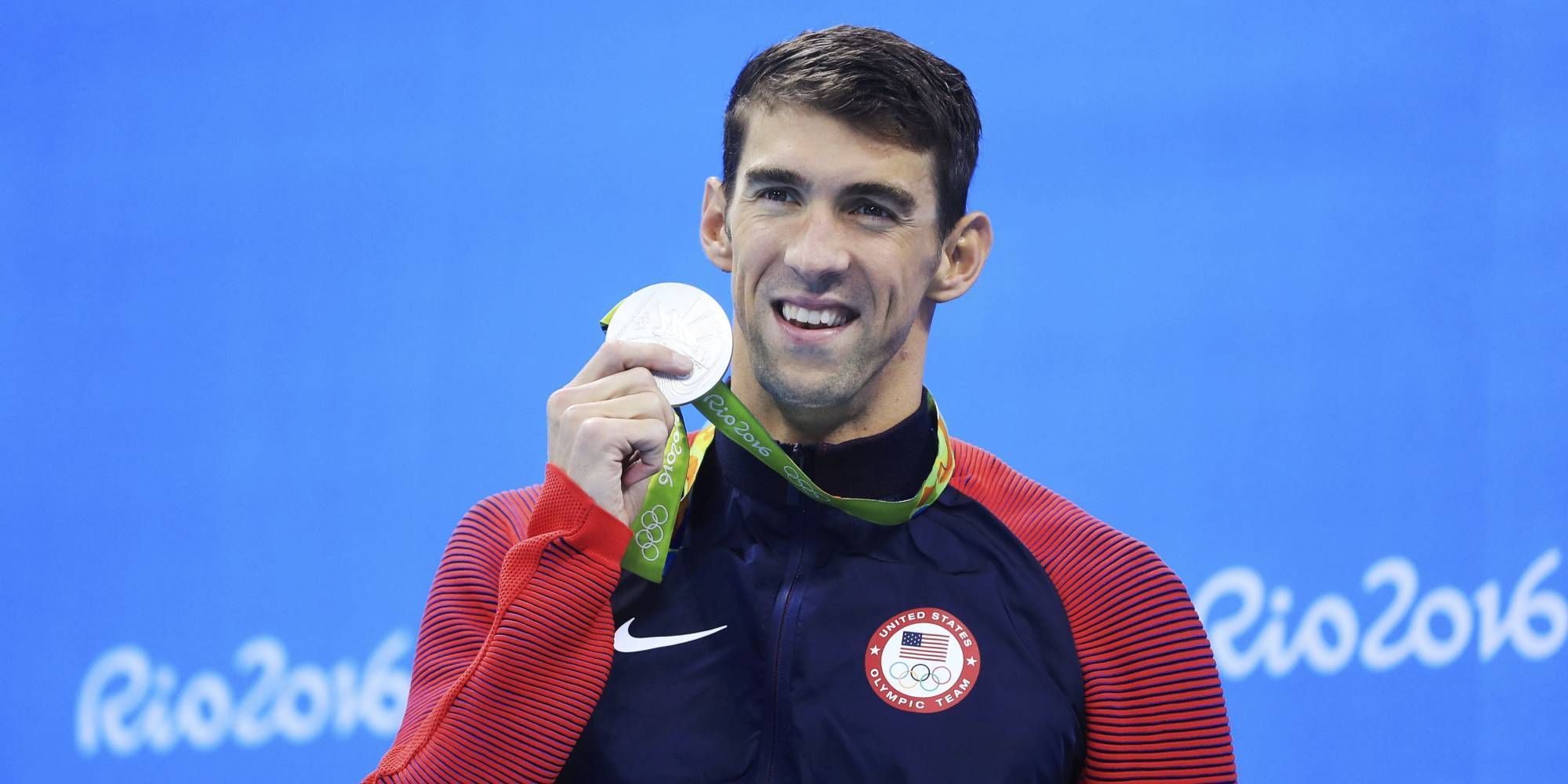 Michael Phelps holds up a medal at the Rio 2016 Olympics