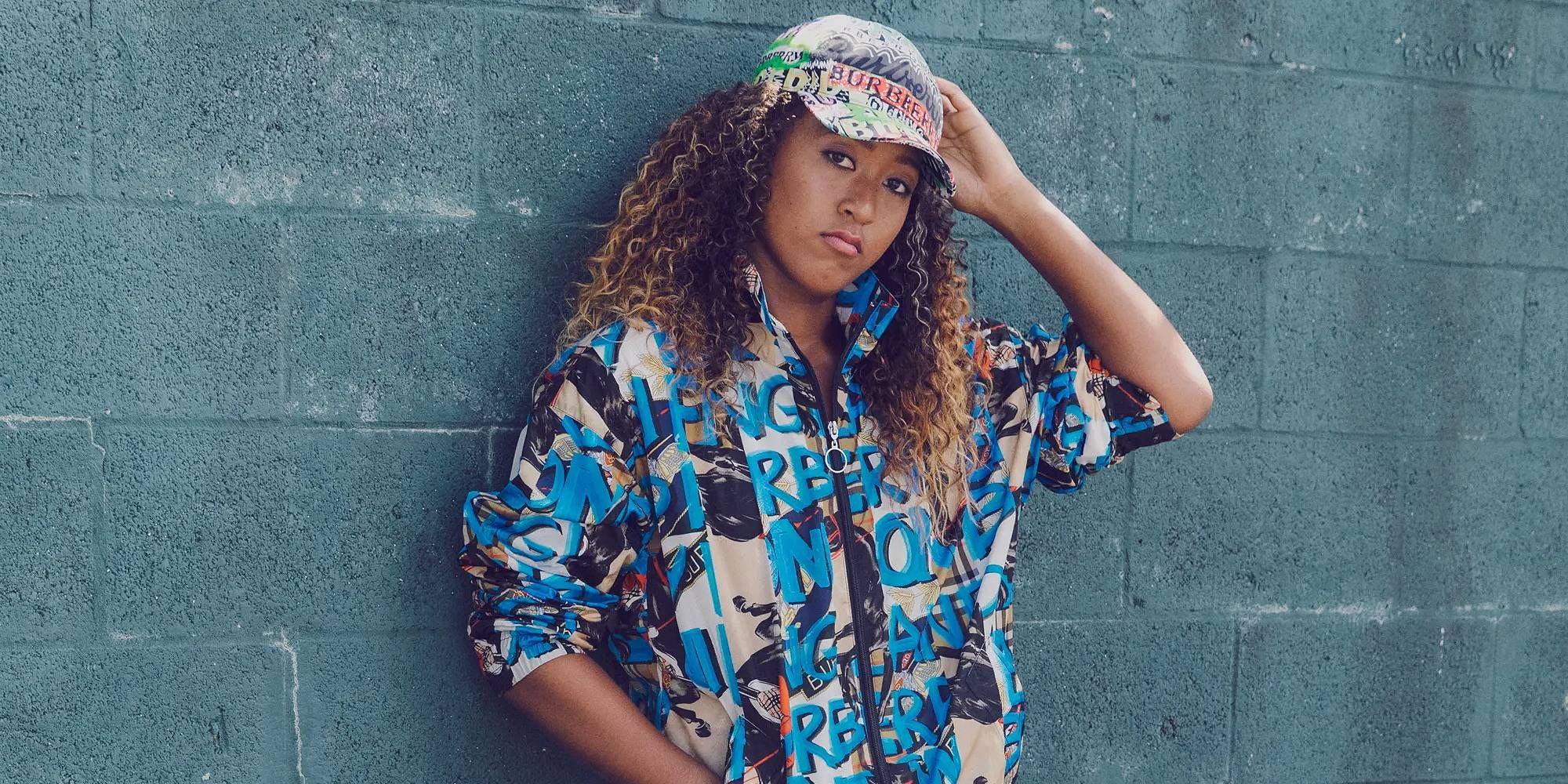 Naomi Osaka standing against a blue wall in the GQ Japan photoshoot