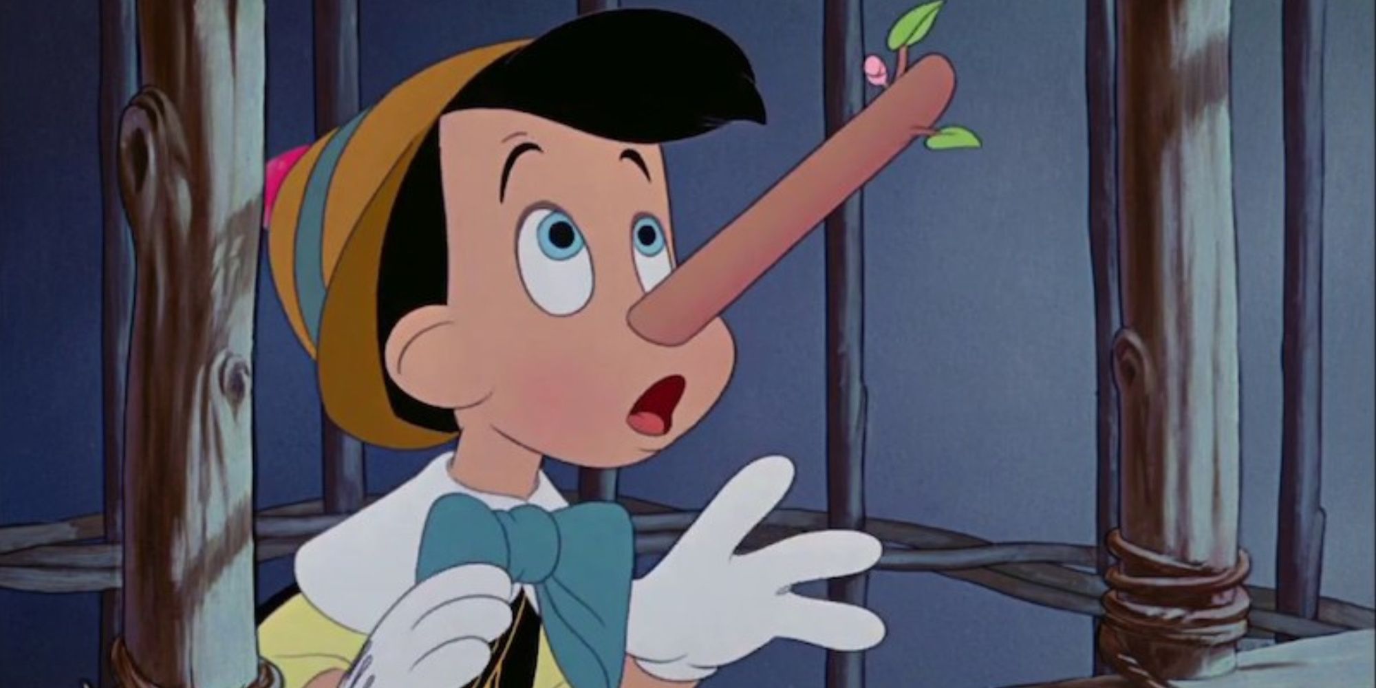 Pinocchio facing the right, in a wooden cage, his nose growing from a lie