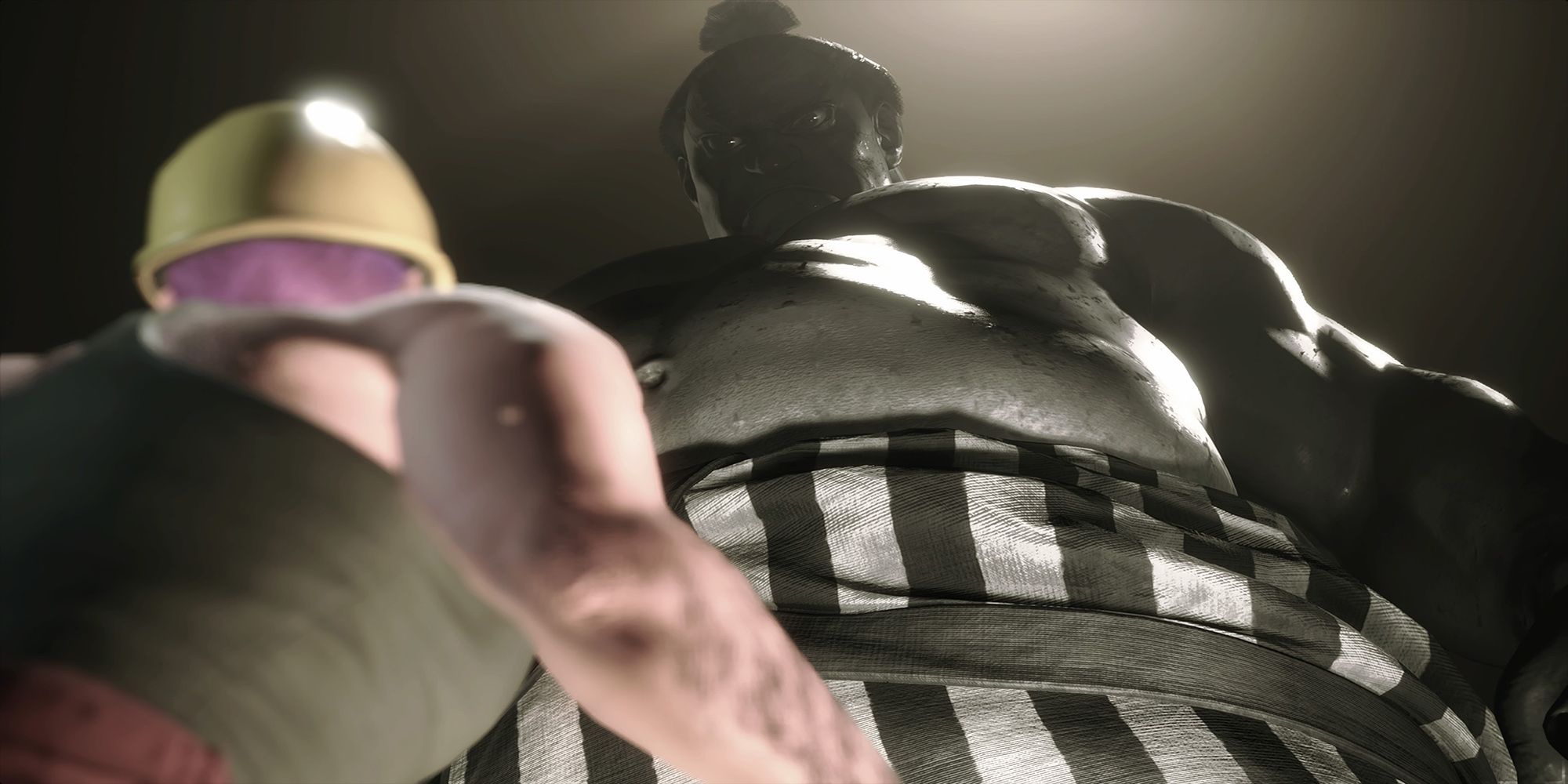 An imposing E Honda towers over the player avatar during a sumo battle in Street Fighter 6.