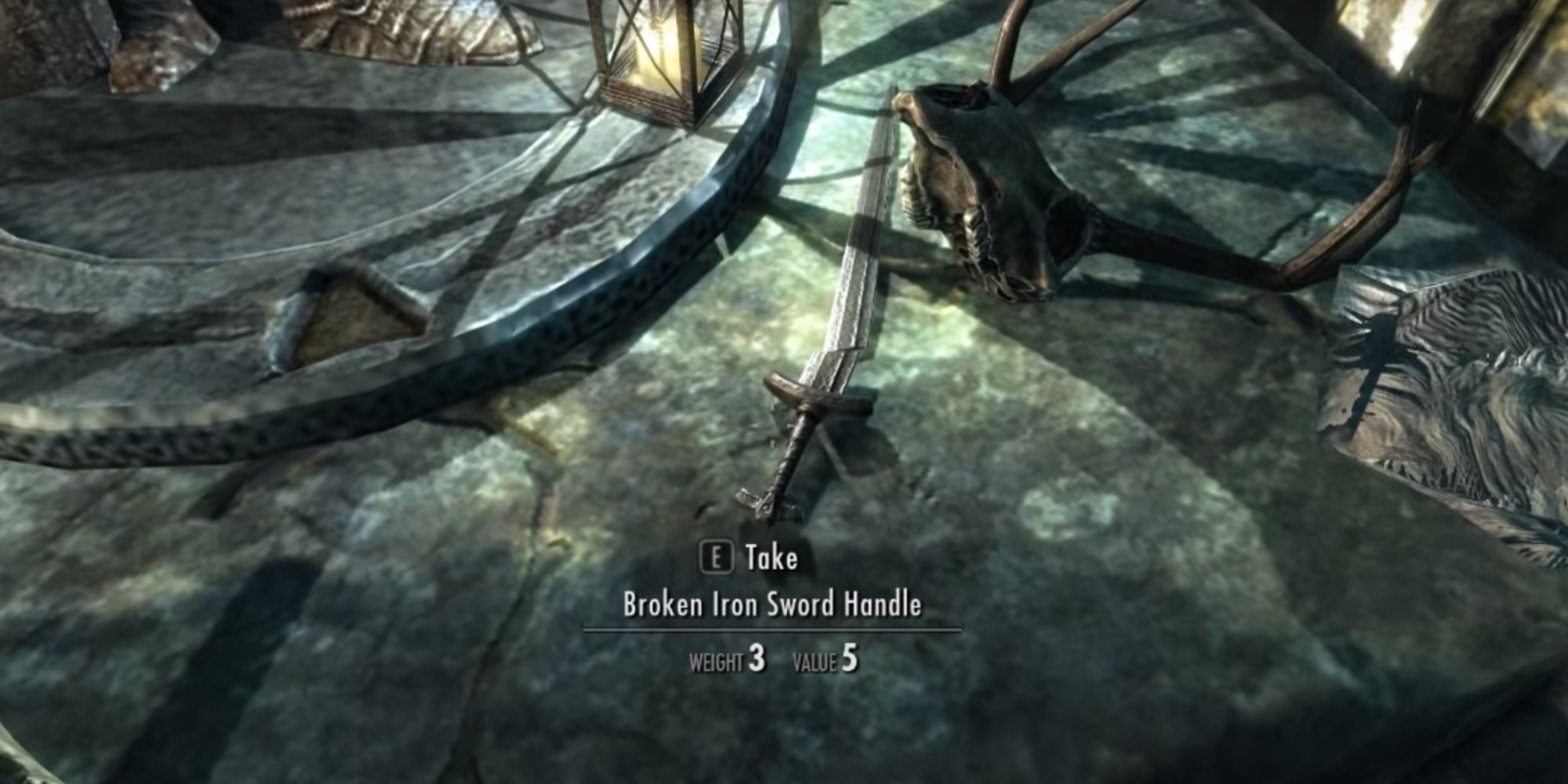 A Broken Iron Sword Blade And Handle lay next to one another on a stone slab in Skyrim.
