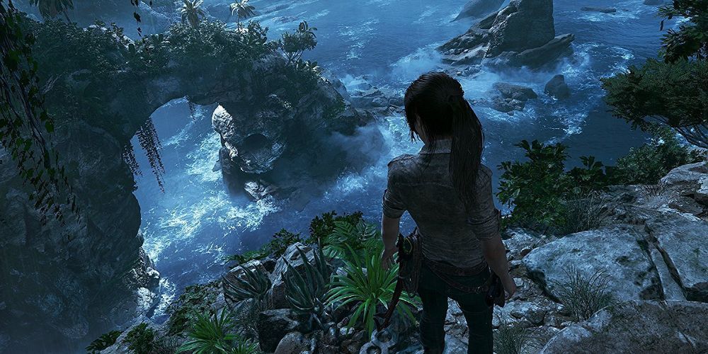 Lara standing atop a cliff overlooking the sea