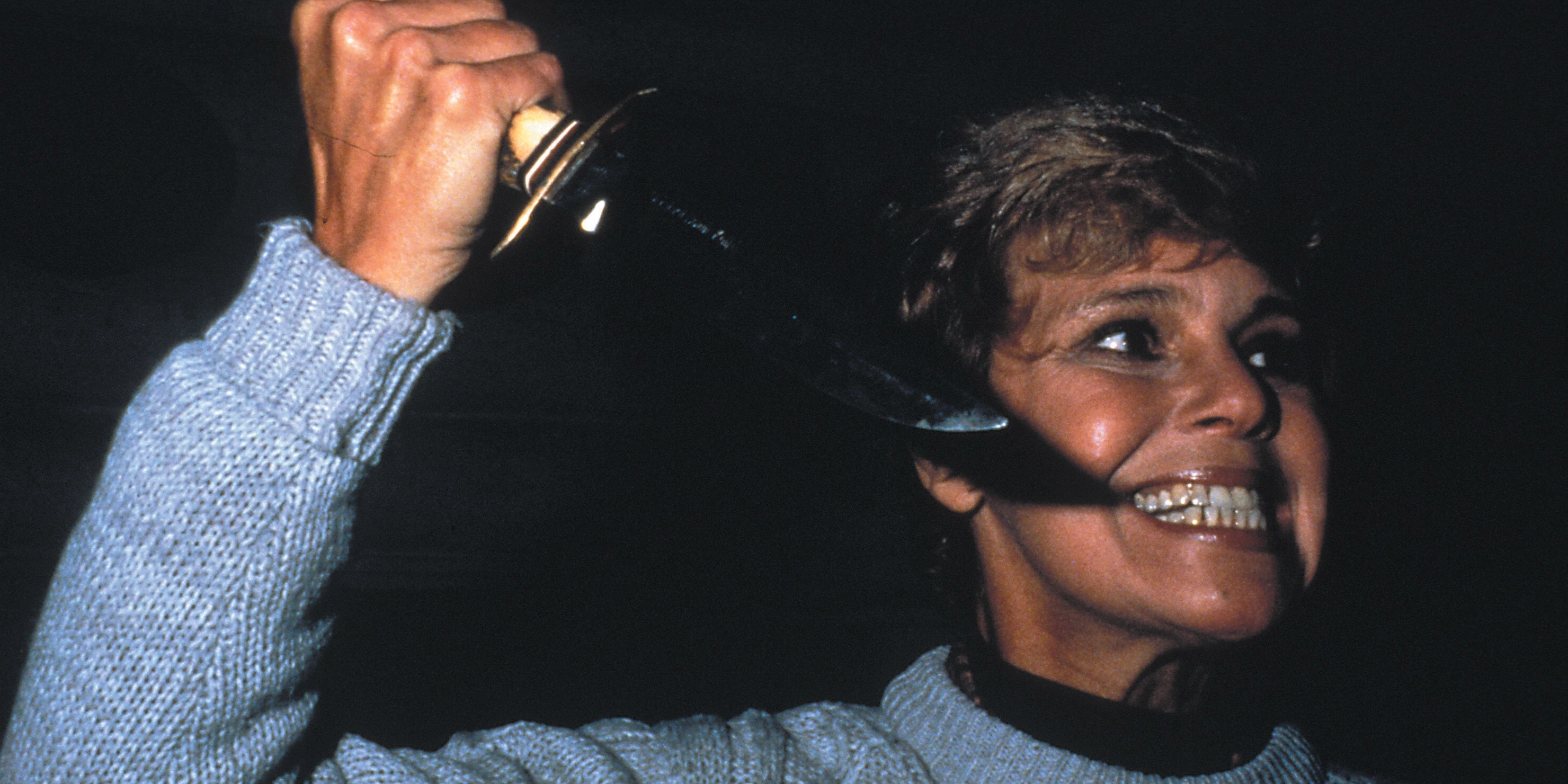 Pamela Vorhees from Friday the 13th with a manic smile and wielding a hunting knife