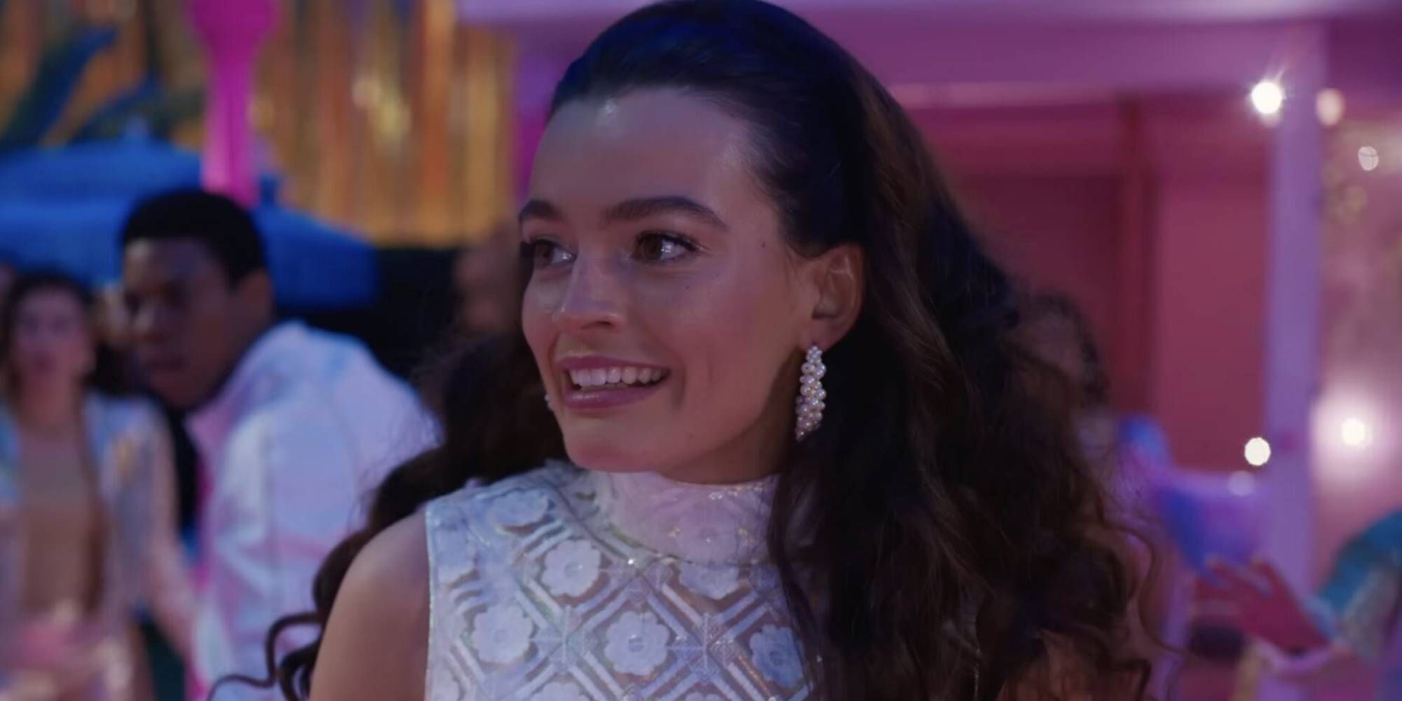 A brown haired woman smiles awkwardly at a party
