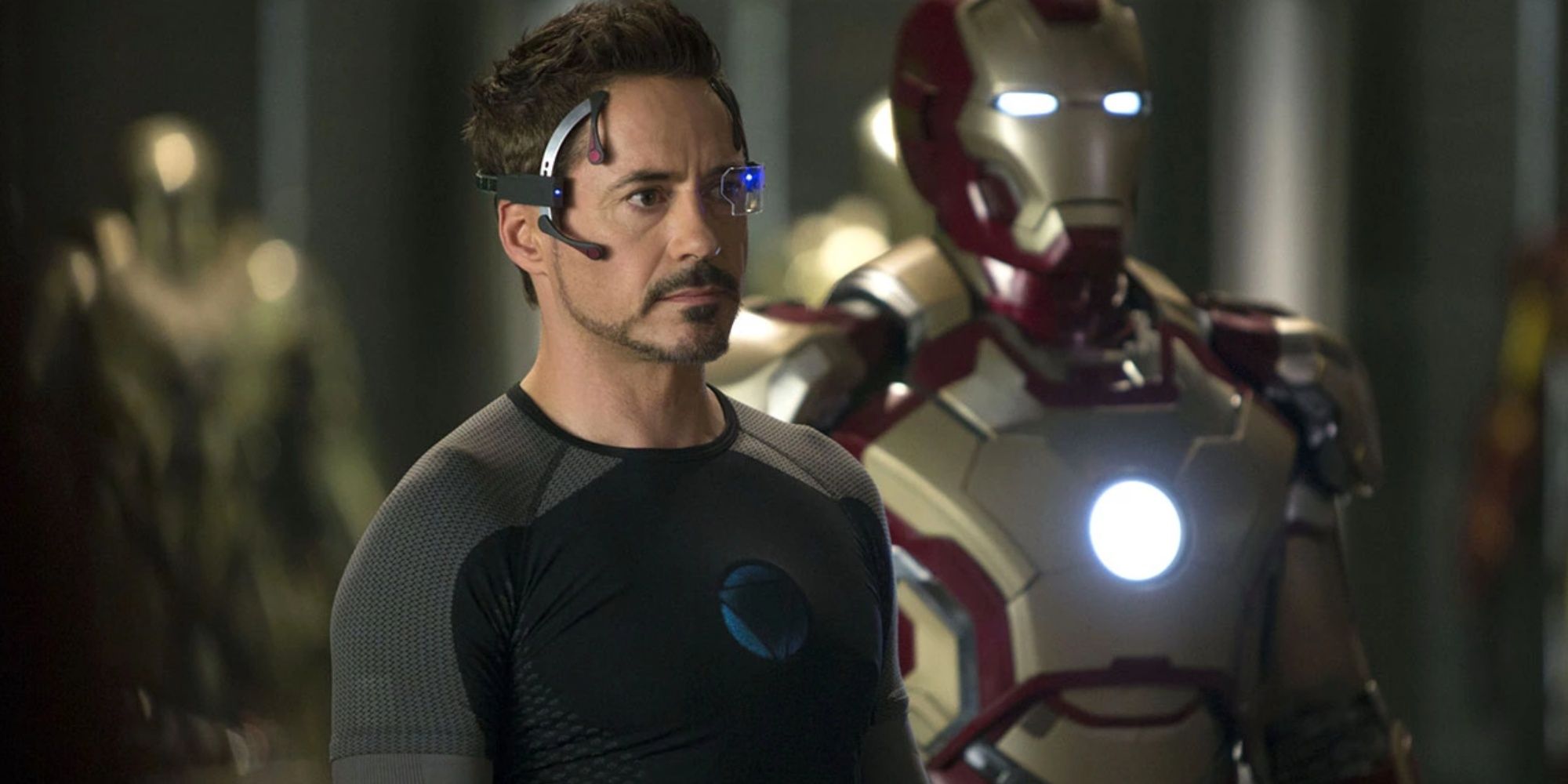 Tony Stark (Robert Downey Jr.) next to his Mark 42 suit, in Iron Man 3