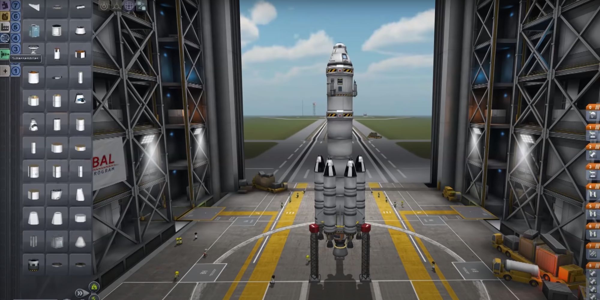 A tall, multi-stage rocket in the ship building area within Kerbal Space Program.