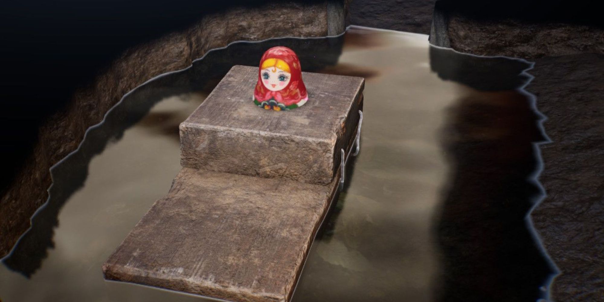 The Mama Doll Head sits on a rock surrounded by water