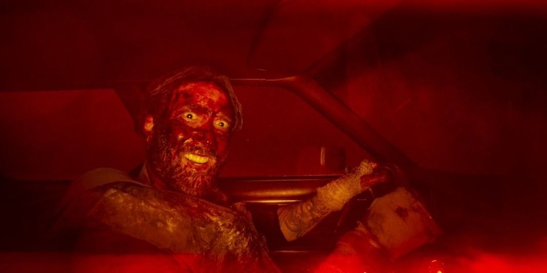 Mandy - Red Miller drives a car whilst smiling creepily at the camera