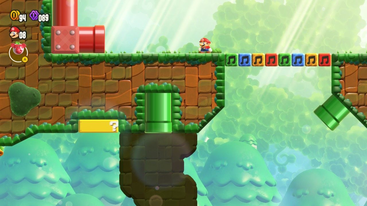 Mario on an above platform with a red pipe to his left.