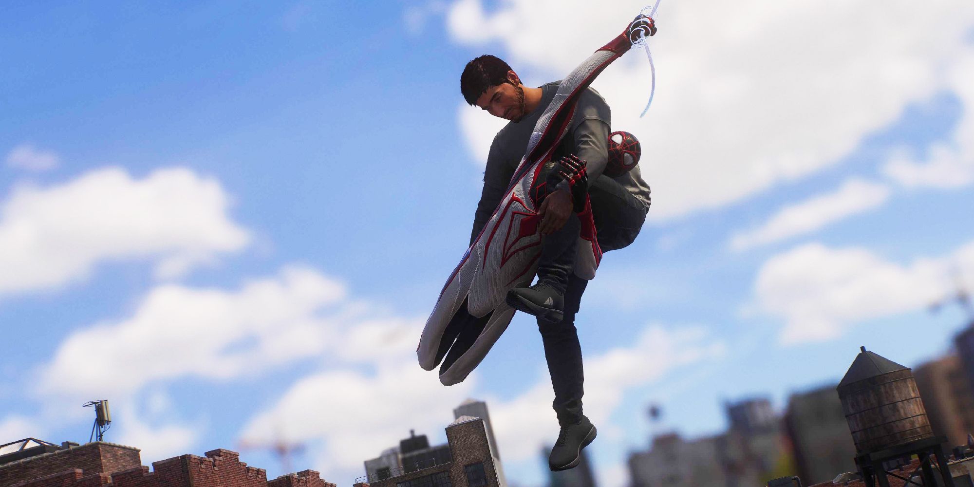 Spider-Man 2 screenshot of Miles Morales swinging through New York City, carrying an injured person to hospital