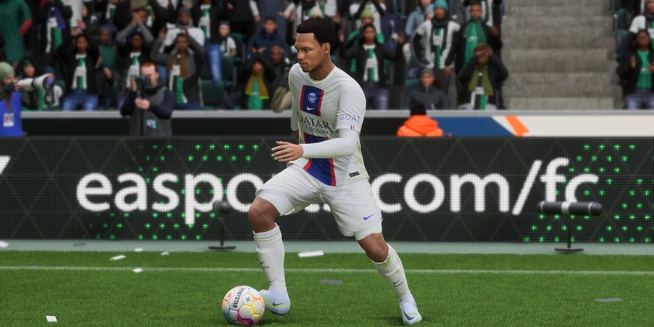 Paris Saint Germain footballer on the ball in front of an advertising board for EA Sports FC