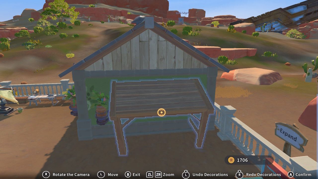 Player character in the Construction Junction build mode and placing a large wooden portico on the side of their green house next to a potted plant in My Time Time At Sandrock.