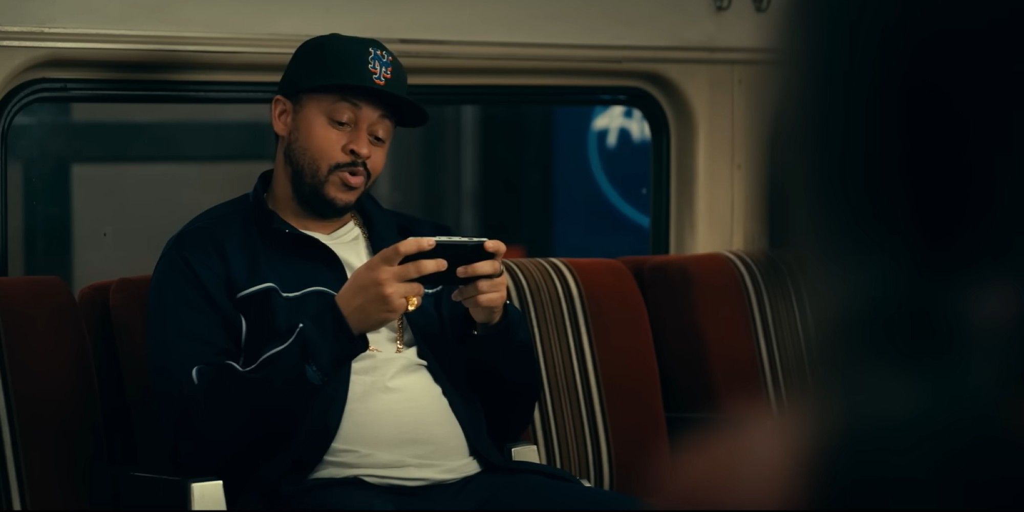 A character playing a PSP on the subway in Madame Web