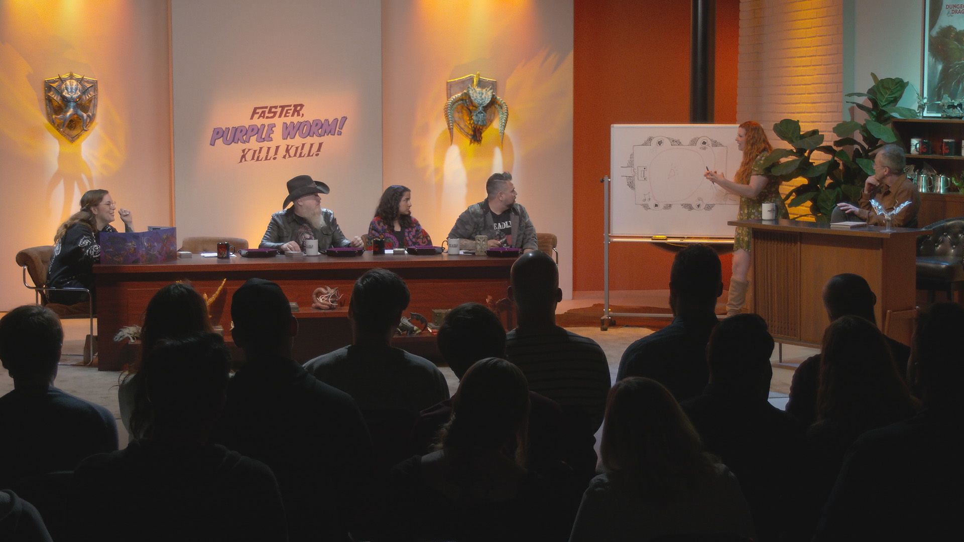 Faster Purple Worm! Kill! Kill! cast sat at a table in front of an audience