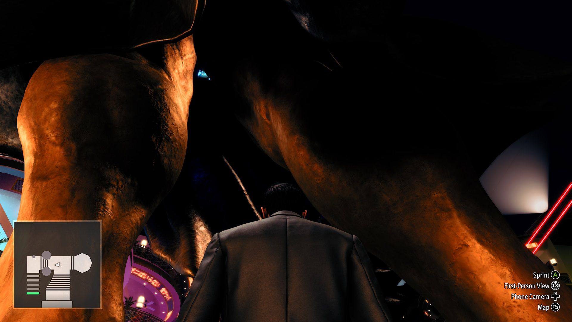 Kiryu looking up between the legs of a statue in Like a Dragon Gaiden.
