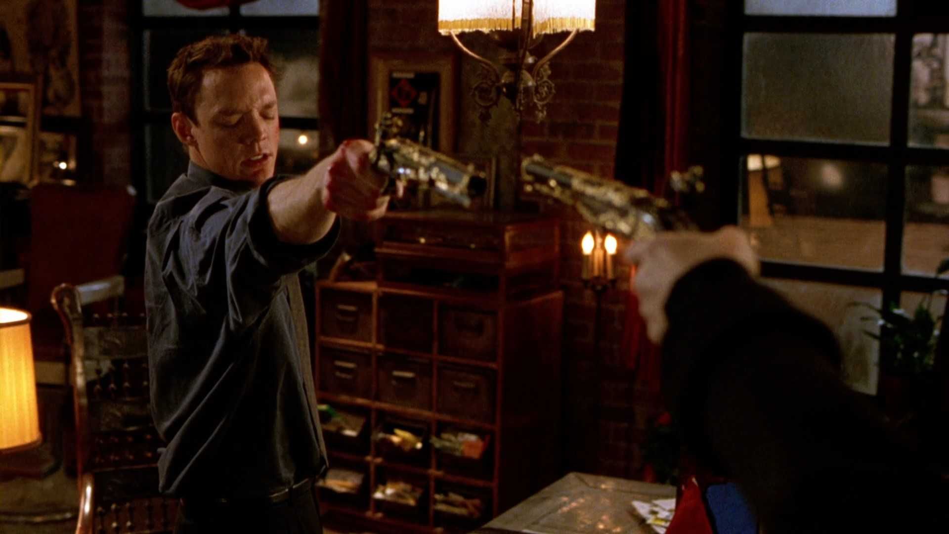 Matthew Lillard with his eyes closed pointing a gun in Spanish Judges