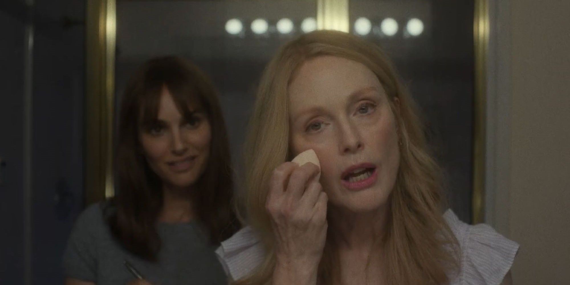 Julianne Moore putting on makeup in May December while Natalie Portman watches