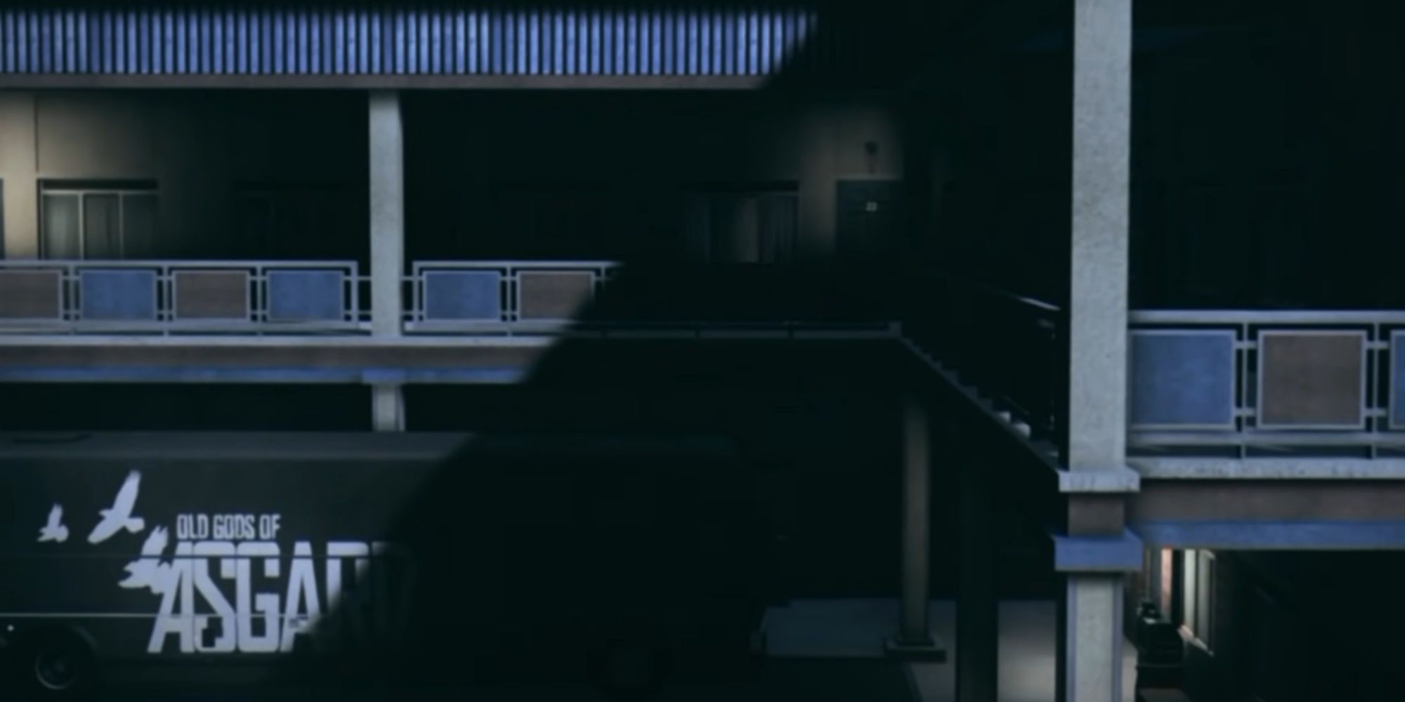 An exterior view of the motel outside of Barry's room, a shadow cast over the Old Gods of Asgard logo on the tour bus.