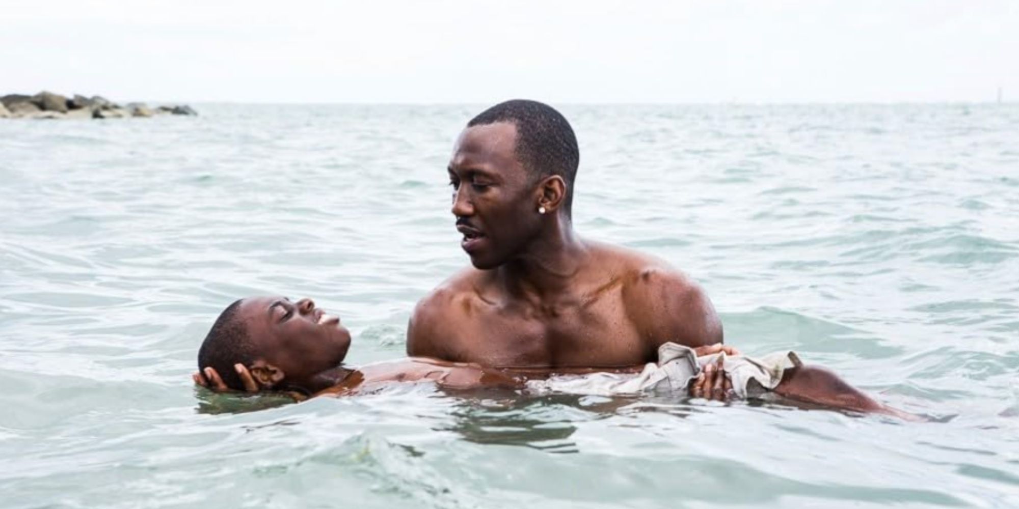 Mahershala Ali's character Juan holding a young Chiron in his arms in the ocean.