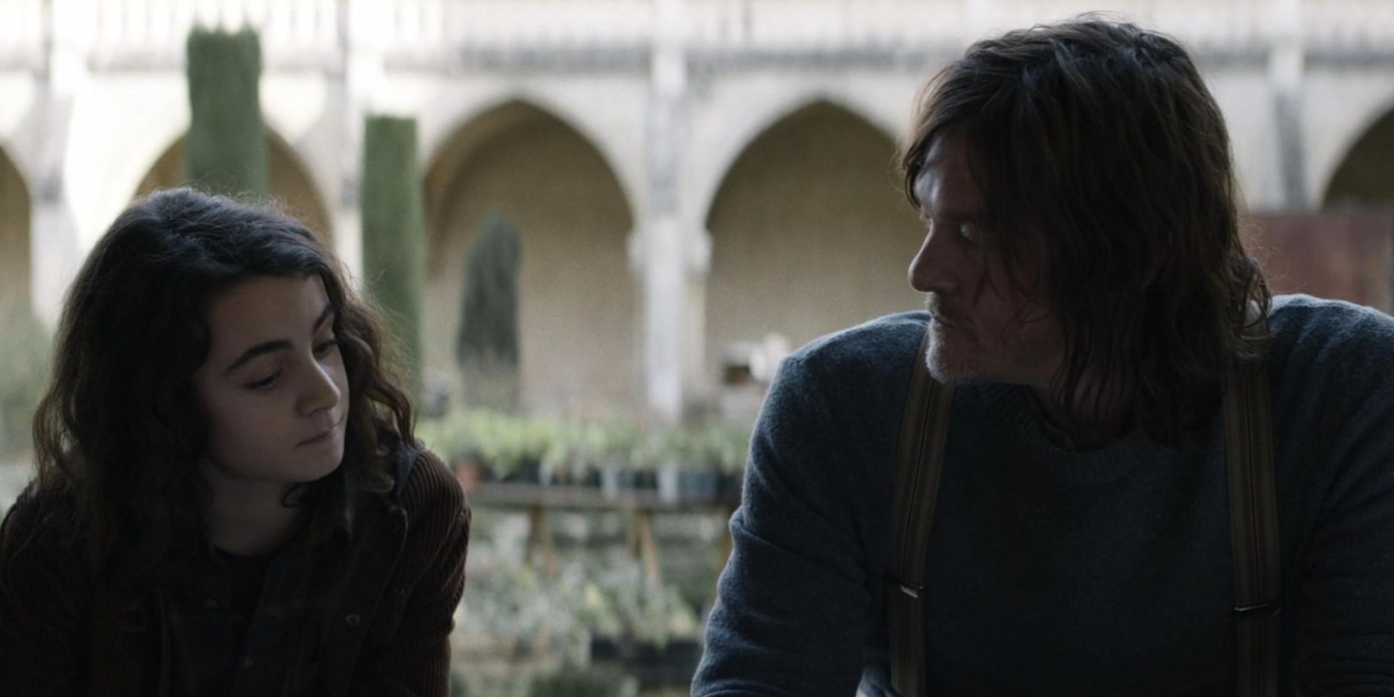 Daryl speaking with Laurent in a garden area of the Convent in The Walking Dead: Daryl Dixon.