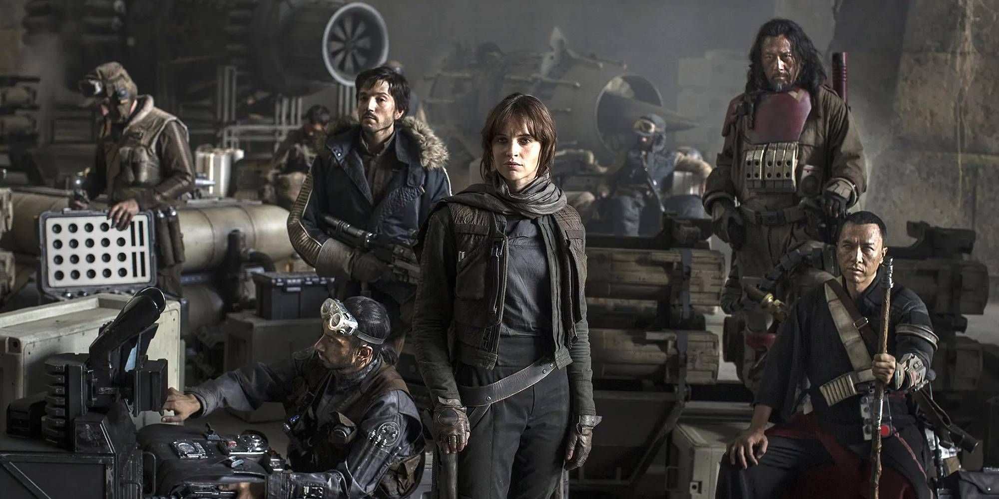 The main cast of Star Wars Rogue One stand in a messy Rebellion base