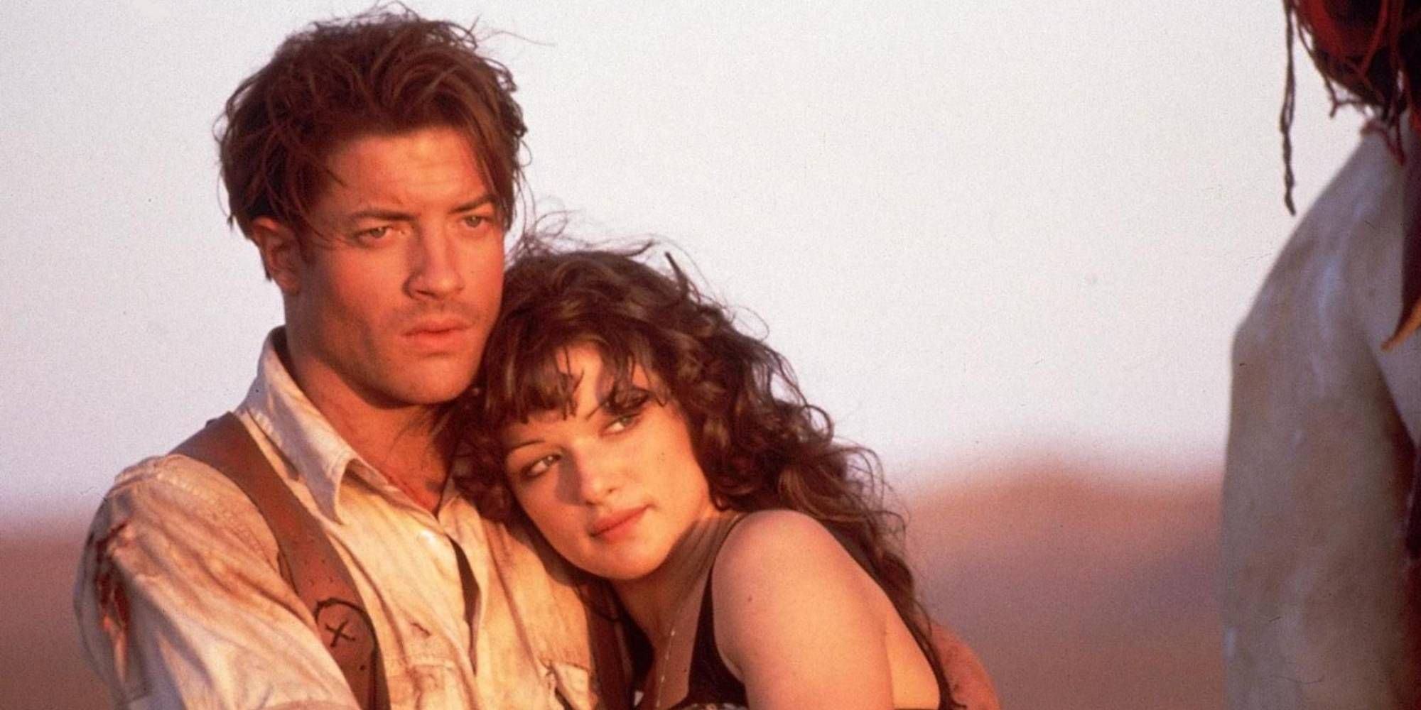 Brendan Fraser and Rachel Weisz holding each other in a sunny desert from The Mummy