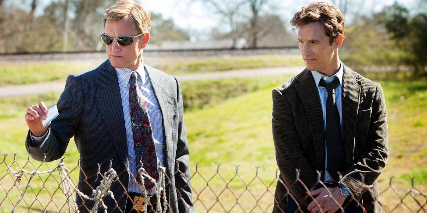Rust and Marty standing in front of a fence