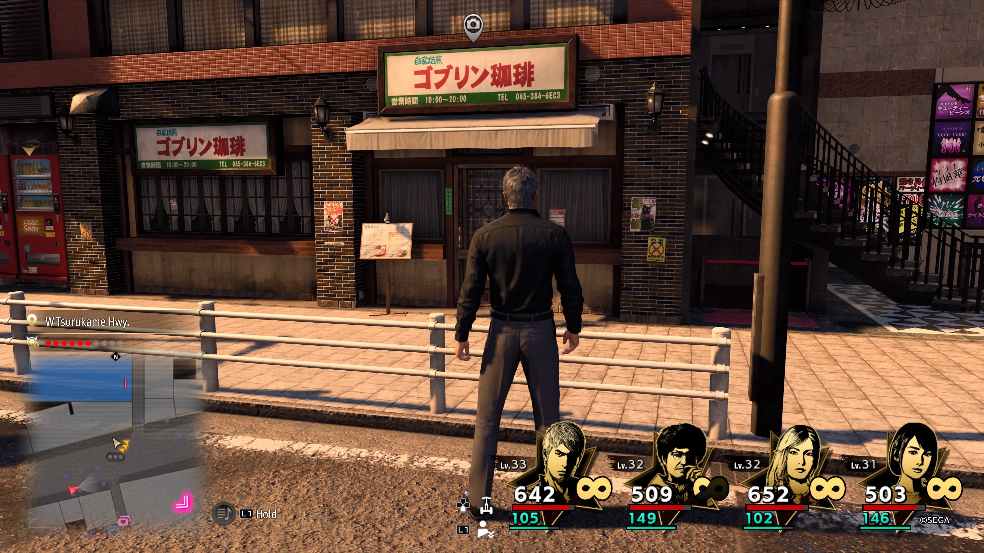 Kiryu standing in front of the Goblin Coffee cafe in downtown Yokohama in Like A Dragon: Infinite Wealth.