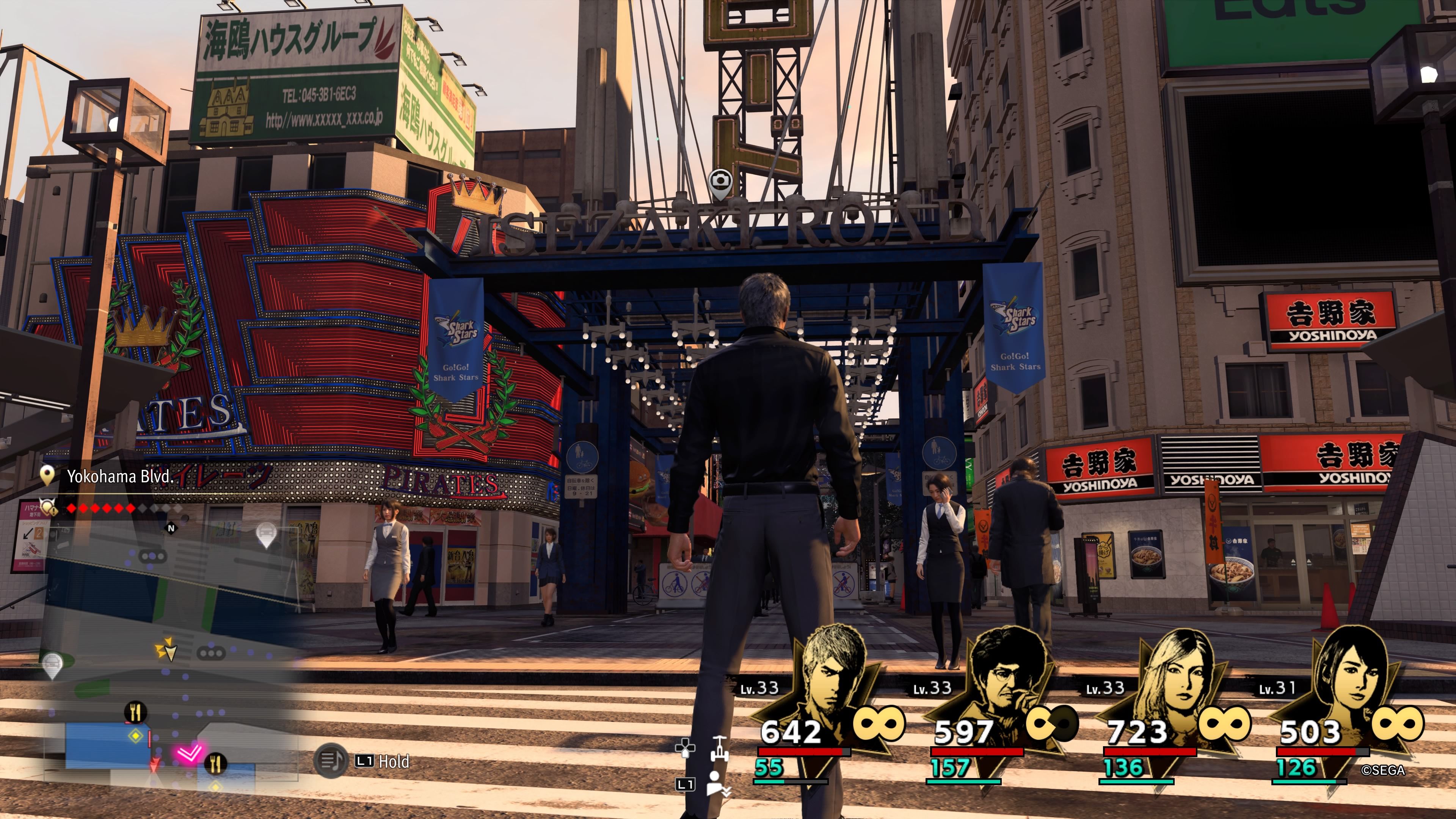Kiryu standing beneath the large lighted sign entrance to Isezaki Road in Like A Dragon: Infinite Wealth.