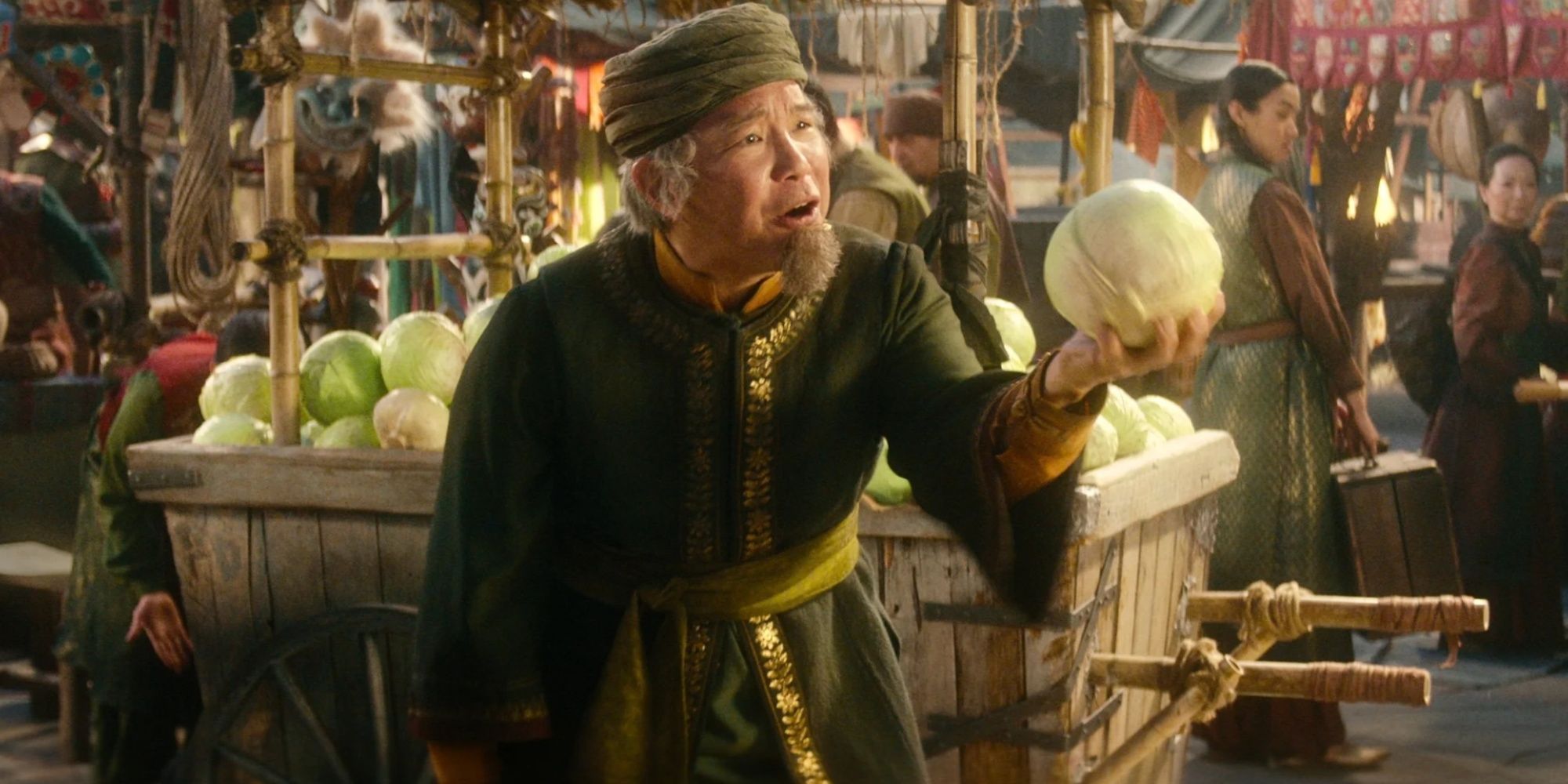 cabbage vendor holding up a cabbage in front of his cart in the market in Omashu, the last airbender, netflix