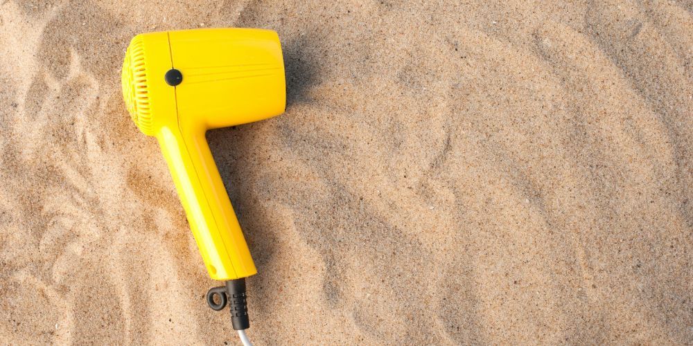 Yellow Travel Hair Dryer On Sand