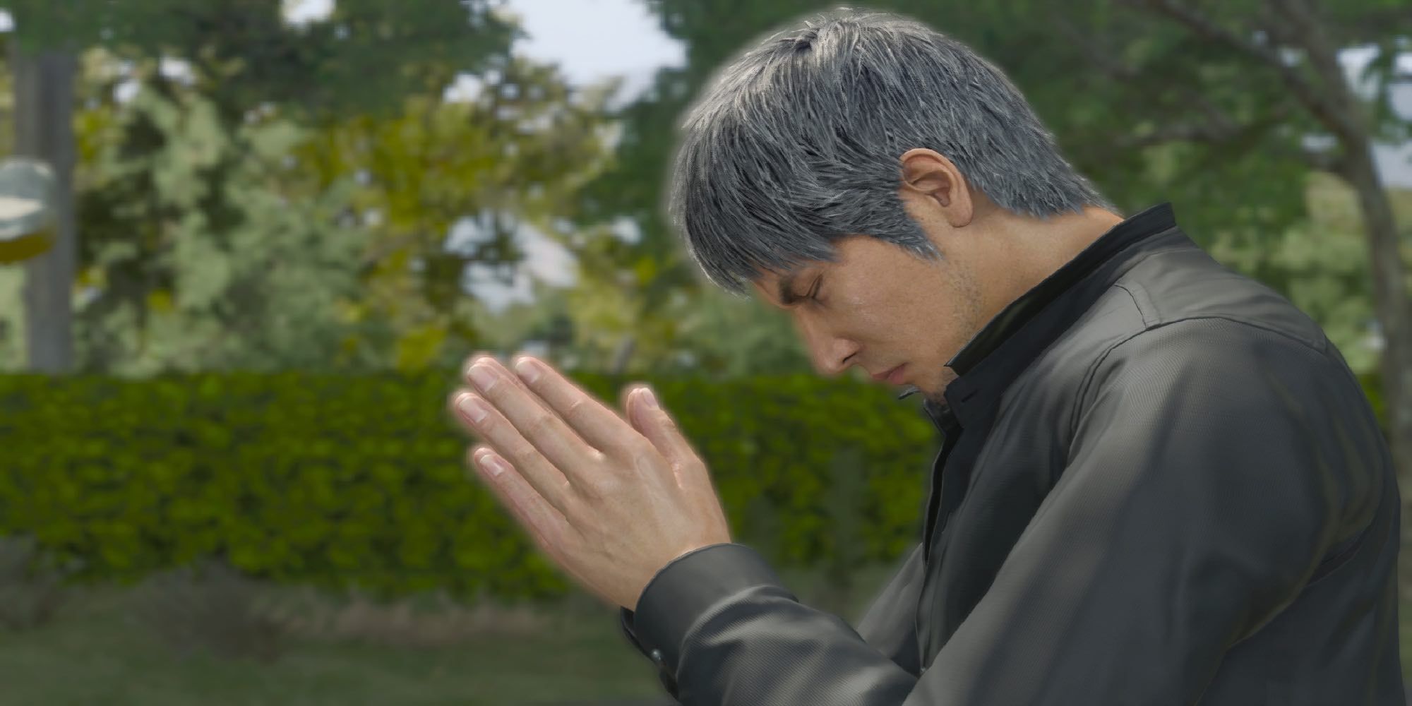 Kiryu praying at a cemetery in Like A Dragon: Infinite Wealth.