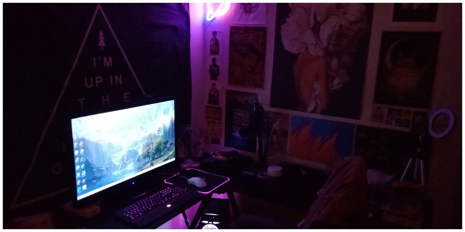 A dimly lit setup that focuses on maximizing wallspace through a tapestry and posters.