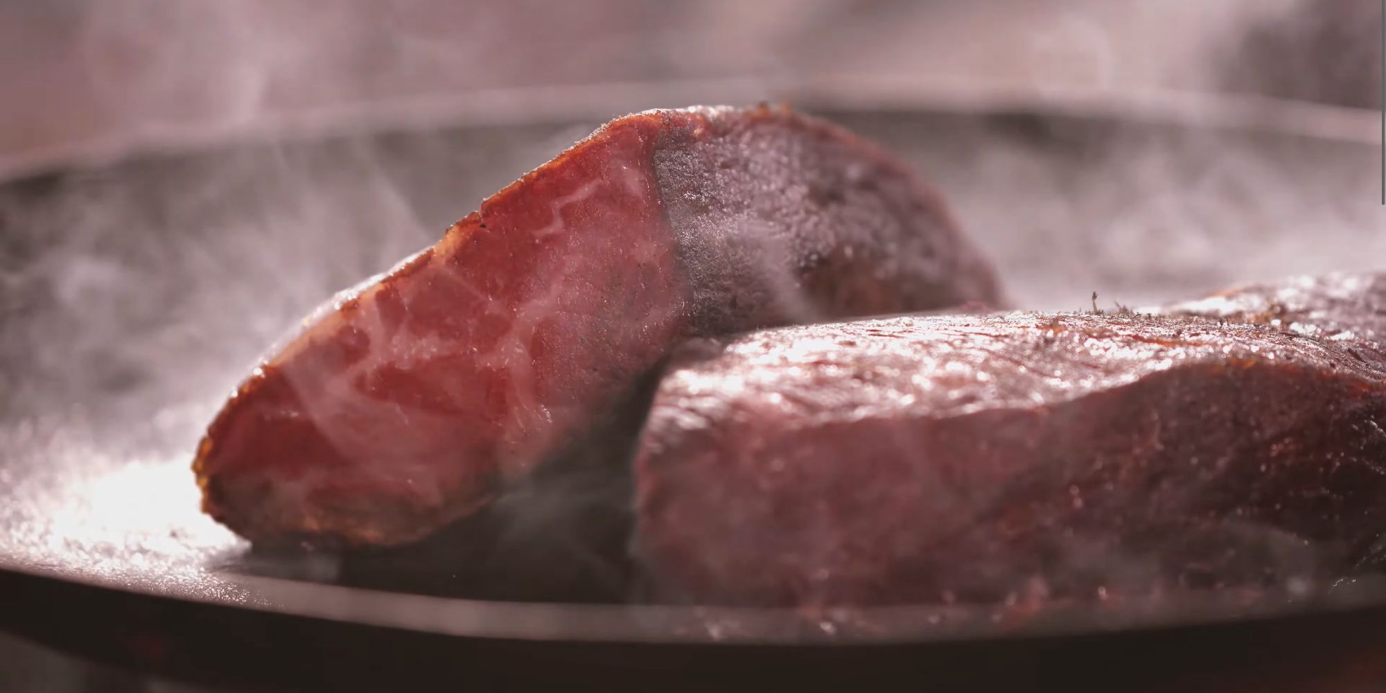 A close up of a plate of meat sizzling away, surrounded by light smoke in Dragon's Dogma 2