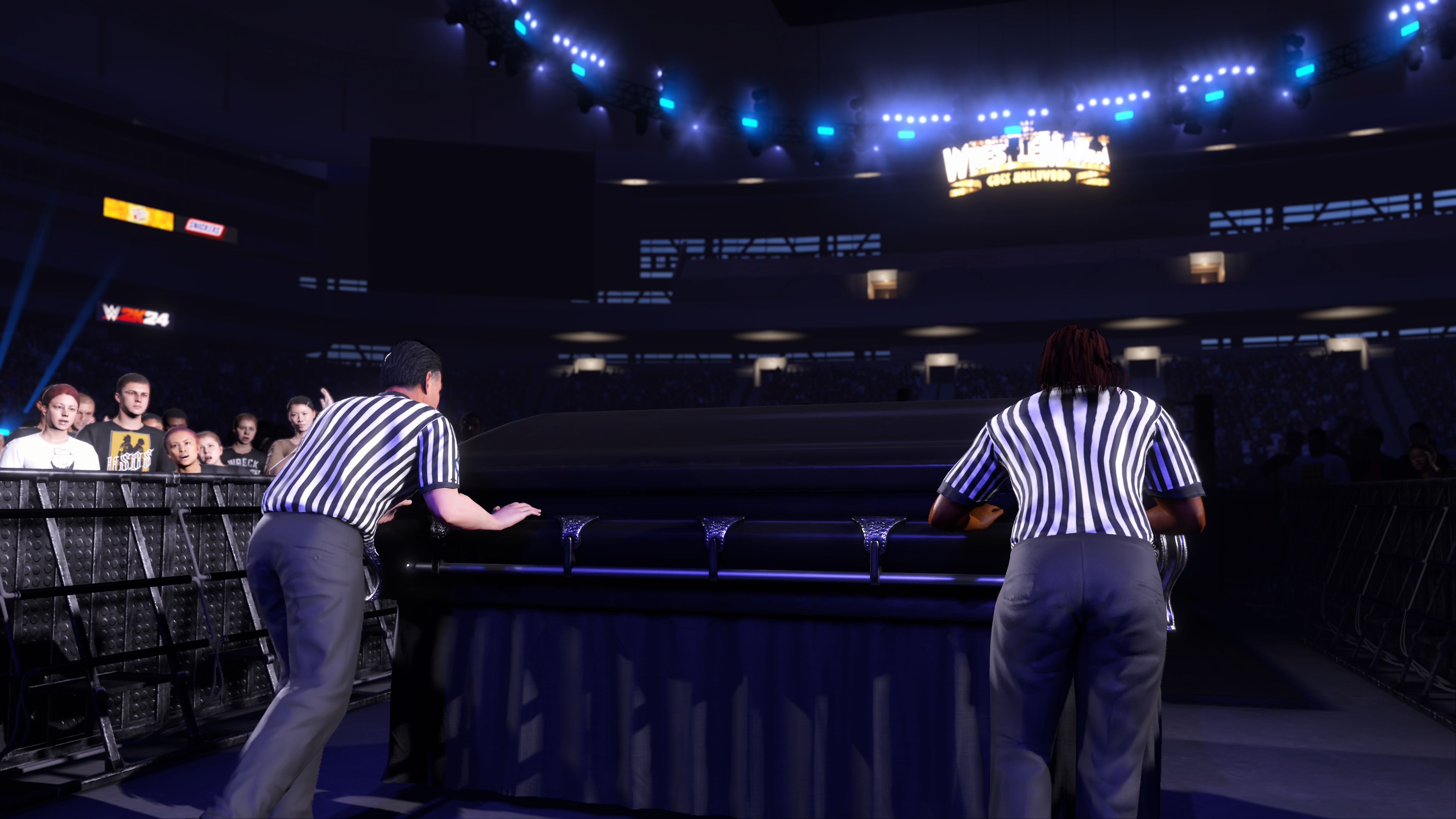 Two referees push a casket to the ring prior to a Casket Match in WWE 2K24.